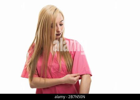 Ritratto di giovane infermiera carina organizzare la sua manica isolata su sfondo bianco con spazio di copia pubblicità area Foto Stock