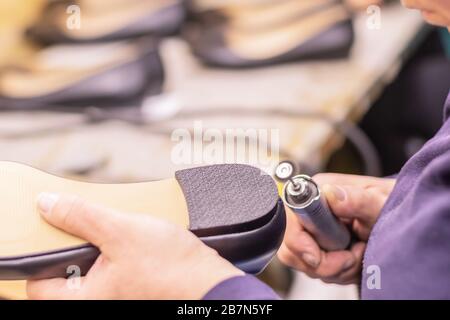 Episodio di lavoro nello studio processo di produzione delle scarpe in fabbrica Foto Stock