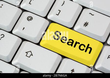 Una tastiera con la scritta Search in nero su un tasto giallo invio. Concetto di Search Engine. Inghilterra, Regno Unito, Gran Bretagna Foto Stock