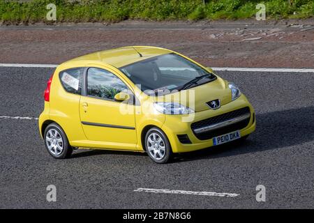 Targhe commerciali su 2010 Peugeot 107 Urban giallo; traffico veicolare del Regno Unito, trasporto, veicoli in movimento, veicolo, strade, motori, motorizzazione sull'autostrada M6 Foto Stock