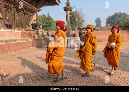 Bhaktapur, Nepal - 28 gennaio 2020: Giovani monaci buddisti che camminano al mattino elemosine a Bhaktapur in Nepal Foto Stock