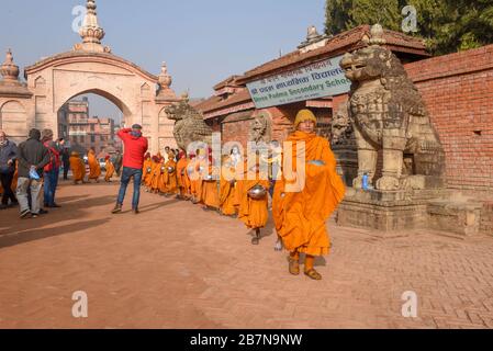 Bhaktapur, Nepal - 28 gennaio 2020: Giovani monaci buddisti che camminano al mattino elemosine a Bhaktapur in Nepal Foto Stock