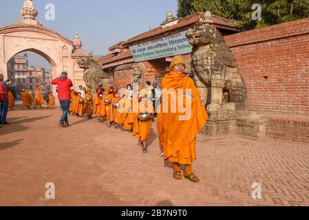 Bhaktapur, Nepal - 28 gennaio 2020: Giovani monaci buddisti che camminano al mattino elemosine a Bhaktapur in Nepal Foto Stock