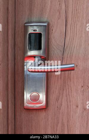 Moderna maniglia della porta sulla porta in legno della camera d'hotel Foto Stock