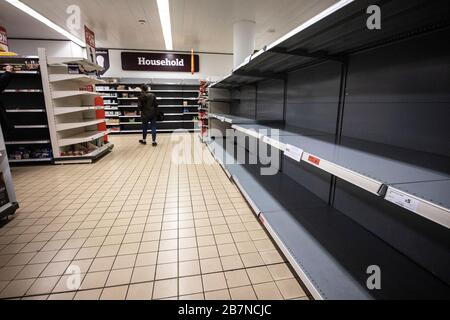 Scaffali vuoti in un supermercato che di solito contengono disposizioni domestiche sdoganate da persone interessate da difficoltà di fornitura dovute covid -19 Foto Stock