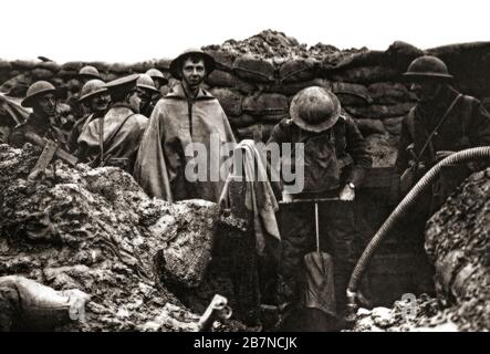 Soldati del Lancashire Fusiliers che pompano acqua da una trincea vicino Ploegsteert Wood, un settore del fronte occidentale nelle Fiandre nella regione vallone del Belgio nord-occidentale. Foto Stock