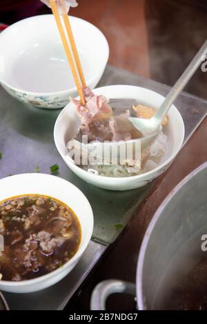Vietnam, Hue. Cibo e bevande. Bun Bo - zuppa di manzo piccante e spaghetti in un ristorante locale Foto Stock