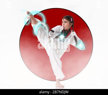 Piccola karate girl fa un calcio sullo sfondo della bandiera giapponese. Il concetto di potere potenziale. Formazione regolare e forza di volontà Foto Stock