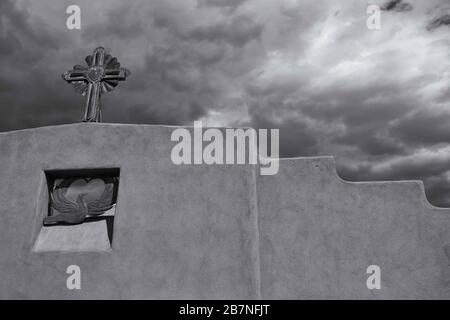 Immagine in scala di grigi di una croce sulla parte superiore di una parete Nel Nord del New Mexico Foto Stock