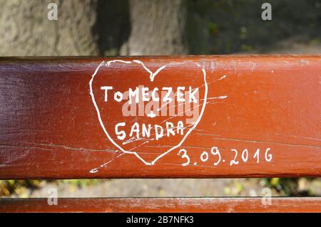 POZNAN, POLONIA - 12 giu 2019: Messaggio d'amore con i nomi su una panchina del parco. Foto Stock