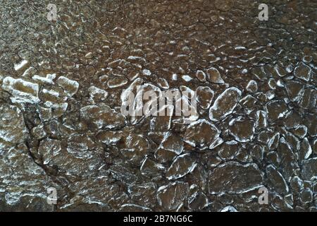 Pezzi di ghiaccio galleggiante sulle onde, placche di ghiaccio, costa sabbiosa, pietre, paesaggio primaverile, tempo soleggiato, pacificazione Foto Stock