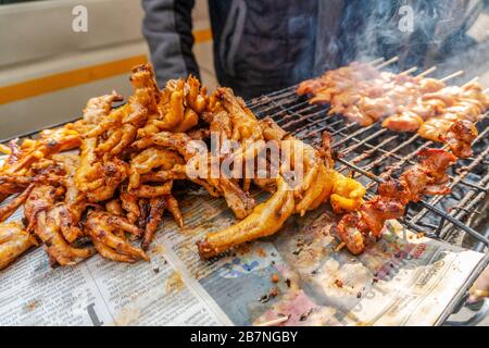 Cibo di strada locale sudafricano - spiedini di pollo alla griglia e piedi Foto Stock