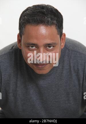 Un uomo indiano in uno studio contro uno sfondo bianco che guarda alla macchina fotografica Foto Stock