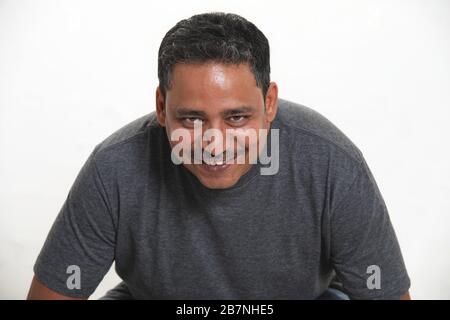 Un uomo indiano sorridente in uno studio su uno sfondo bianco che guarda alla macchina fotografica Foto Stock