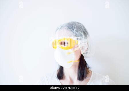 Dottore Donna in maschera utilizzando stetoscopio Foto Stock