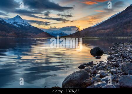 Bellissimo tramonto con montagne innevate dalle rive del lago di Loch Leven vicino a Glencoe nelle Highlands Scottsih Foto Stock
