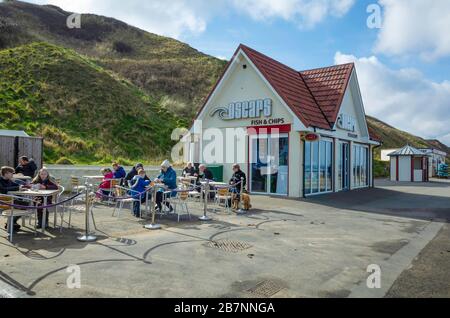 Oscars Fish and chip Shop sul lungomare di Saltburn North Yorkshire affollato di persone che godono il loro cibo all'aperto nel primo sole primaverile Foto Stock