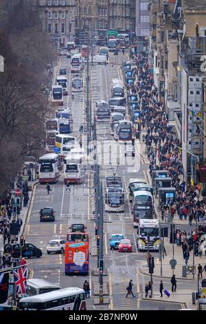 Gli autobus e i tram viaggiano su e giù per Princes Street, la principale strada dello shopping nel centro di Edimburgo. Foto Stock