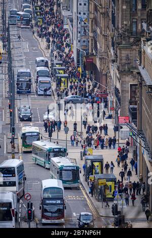 Gli autobus e i tram viaggiano su e giù per Princes Street, la principale strada dello shopping nel centro di Edimburgo. Foto Stock