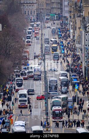 Gli autobus e i tram viaggiano su e giù per Princes Street, la principale strada dello shopping nel centro di Edimburgo. Foto Stock