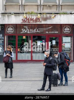 Dublino, Irlanda. 17 Marzo 2020. Festival/parata di San Patrizio di Dublino. O'Connell Street, il centro della città di Dublino, normalmente pieno di visitatori per una delle più grandi celebrazioni culturali del mondo è quasi deserta a causa del Corona Virus / Covid 19. Nella foto sono presenti persone che indossano maschere protettive mentre un'altra mantiene la "distanza sociale" . Credit: Barry Cronin/Alamy Live News Foto Stock