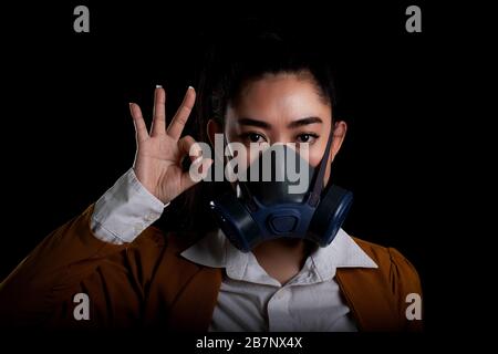 Donna d'affari della giovane Asia donna che mette su una maschera di respiratore N95 per proteggere dalle malattie respiratorie trasportate via aerea come il covid-19 di influenza coronavirus PM2.5 Foto Stock