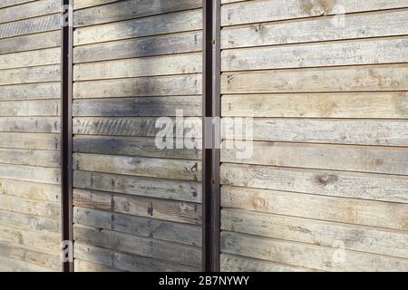 Sfondo in legno con barre metalliche verticali alla luce del sole Foto Stock