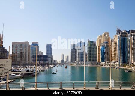 Dubai Marina grattacieli e barche nel porto in una giornata di sole, cielo azzurro chiaro a Dubai, Emirati Arabi Uniti Foto Stock