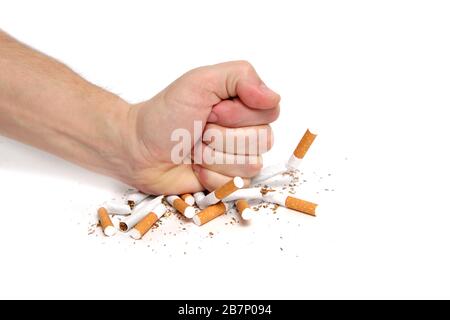 L'uomo schiaccia le sigarette con il suo pugno che si rifiuta di fumare.su sfondo bianco Foto Stock
