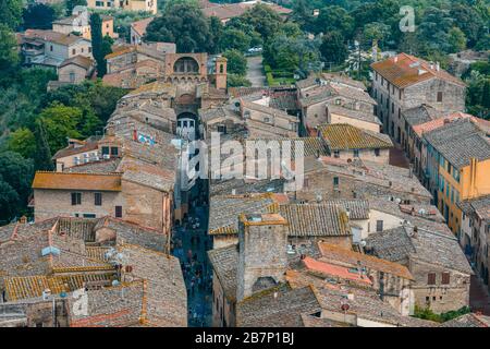 I tetti del centro storico di San Gimignano e di Via S. Giovanni terminano con porta San Giovanni vista dalla Grande Torre grossa, San Gimignano Italia Foto Stock