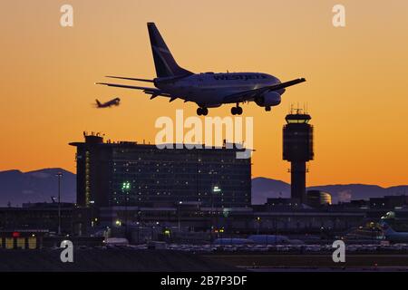 Richmond, British Columbia, Canada. 16 Marzo 2020. Un jet per passeggeri della WestJet Airlines Boeing 737-600 (C-GWCQ) atterra al tramonto, all'aeroporto internazionale di Vancouver, a Richmond. All'inizio del giorno il governo canadese, nel tentativo di fermare la diffusione del romanzo coronavirus, ha annunciato che i confini della nazione sarebbe stato chiuso a partire da mercoledì, a tutti i viaggiatori diversi dai cittadini canadesi e residenti permanenti, cittadini statunitensi, diplomatici e lavoratori essenziali. Credit: Bayne Stanley/ZUMA Wire/Alamy Live News Foto Stock