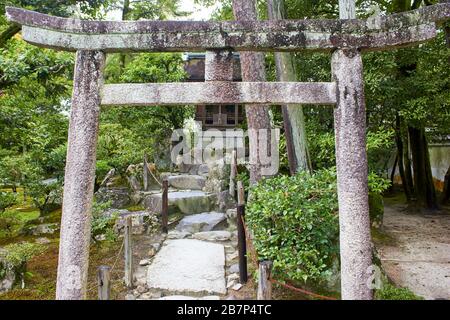 Porte torii in pietra in giardino in stile giapponese Foto Stock