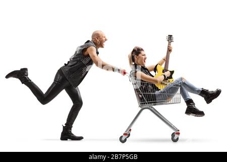 Un punk che gridava e spingeva un carrello con una donna che suona una chitarra all'interno isolata su sfondo bianco Foto Stock