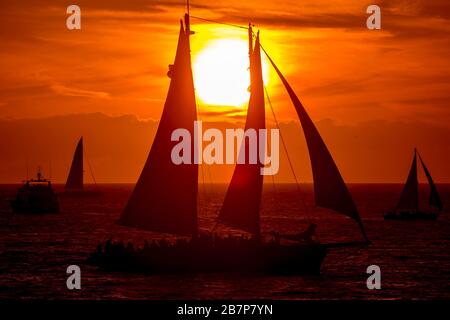 Barche a vela al tramonto sul mare Foto Stock