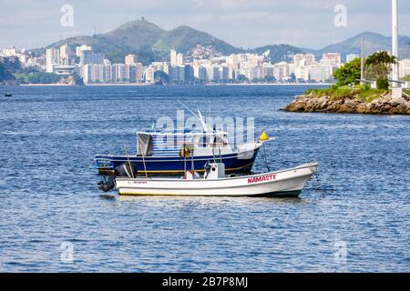 Vista dal quartiere di Urca di piccole barche a motore ormeggiate nella baia di Guanabara e alti blocchi di appartamenti dietro, Rio de Janeiro, Brasile Foto Stock