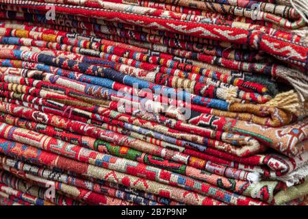 Pile di tappeti caucasici e orientali rappresentate in un negozio georgiano locale. Tbilisi, Georgia Foto Stock