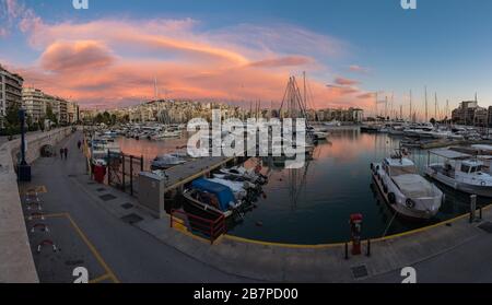 Freattyda, Atene / Grecia - 12 28 2019: Ora d'oro vista panoramica sul porto turistico del Pireo con barche e nuvole rosa Foto Stock