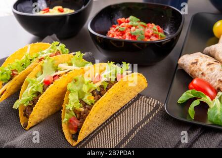 Tre tacos freschi con manzo, mais, pomodori e lattuga. Cucina messicana Foto Stock