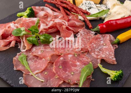 Vari antipasti su un piatto di ardesia. Prosciutto, formaggio, salsiccia. Vista dall'alto Foto Stock