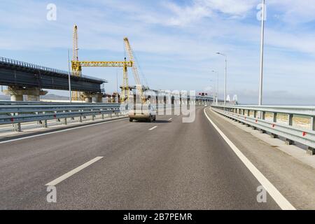 Costruzione di un ponte ferroviario vicino al ponte stradale attraverso lo stretto di Kerch. Davanti archi visibili si estende l'estuario della Senna Foto Stock