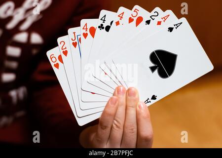 Una persona che tiene e mostra una serie di carte da gioco da poker Foto Stock