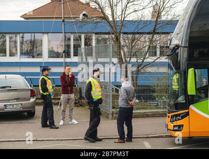 Kehl, Germania - 16 marzo 2020: Conducente di autobus interurbani con maschera bianca di protezione e polizia controllo di ispezione ufficiali al valico di frontiera Kehl Strasburgo misure di crisi contro il coronavirus Foto Stock