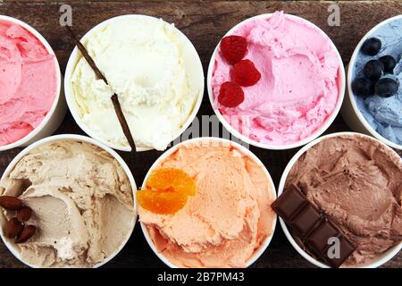 Varie di gelato sapore con mirtillo fresco, fragola, lampone, cioccolato, vaniglia impostazione su sfondo rustico . Estate e gelato dolce Foto Stock