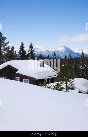 Cabina montagna inverno tempo Gol, Norvegia, con montagne innevate in Hemsedal sullo sfondo. Foto Stock