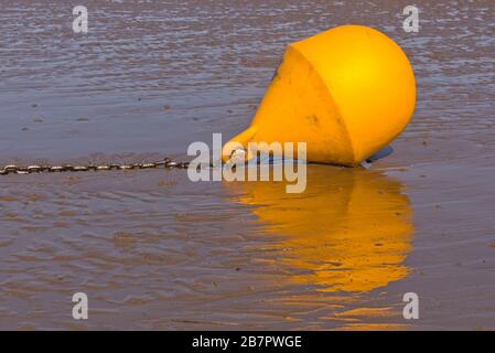 Un segnalino speciale di colore giallo brillante alto e asciutto sul fango accanto al relitto della SS Nornen sulla spiaggia di Berrow sulla costa del Somerset. Foto Stock