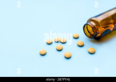 Compresse di medicina farmaceutica e flacone su sfondo blu. Foto Stock