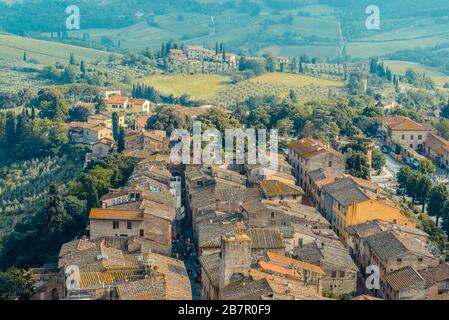 I tetti del centro storico di San Gimignano e di Via S. Giovanni terminano con porta San Giovanni vista dalla Grande Torre grossa, San Gimignano Italia Foto Stock