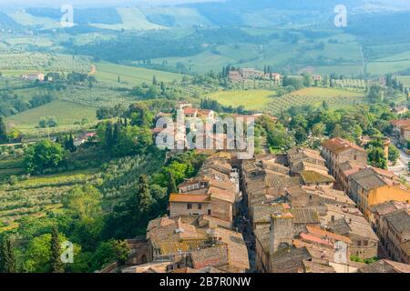 I tetti del centro storico di San Gimignano e di Via S. Giovanni terminano con porta San Giovanni vista dalla Grande Torre grossa, San Gimignano Italia Foto Stock