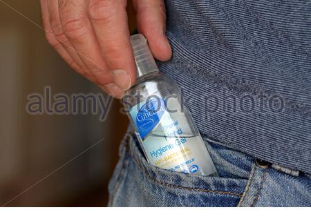 Pratico flacone di gel igienizzante per mani, in tasca jean, per uso in movimento, per la pandemia corrente di coronavirus 19 Foto Stock