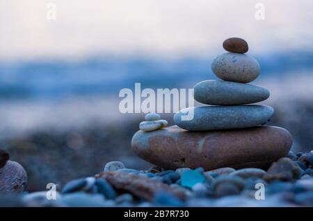 Pila di pietre zen sulla spiaggia ghiaiosa Foto Stock